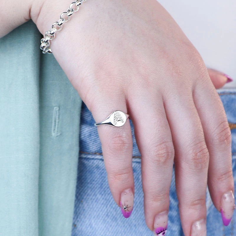 Anillo de sello de plata ajustable con letra pavimentada