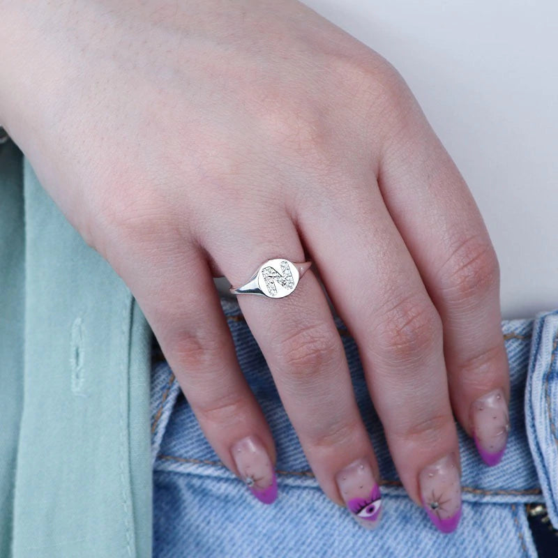 Anillo de sello de plata ajustable con letra pavimentada