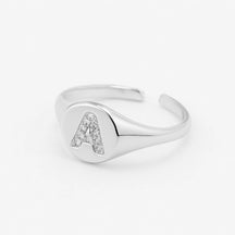 Anillo de sello de plata ajustable con letra pavimentada