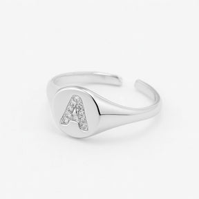 Anillo de sello de plata ajustable con letra pavimentada